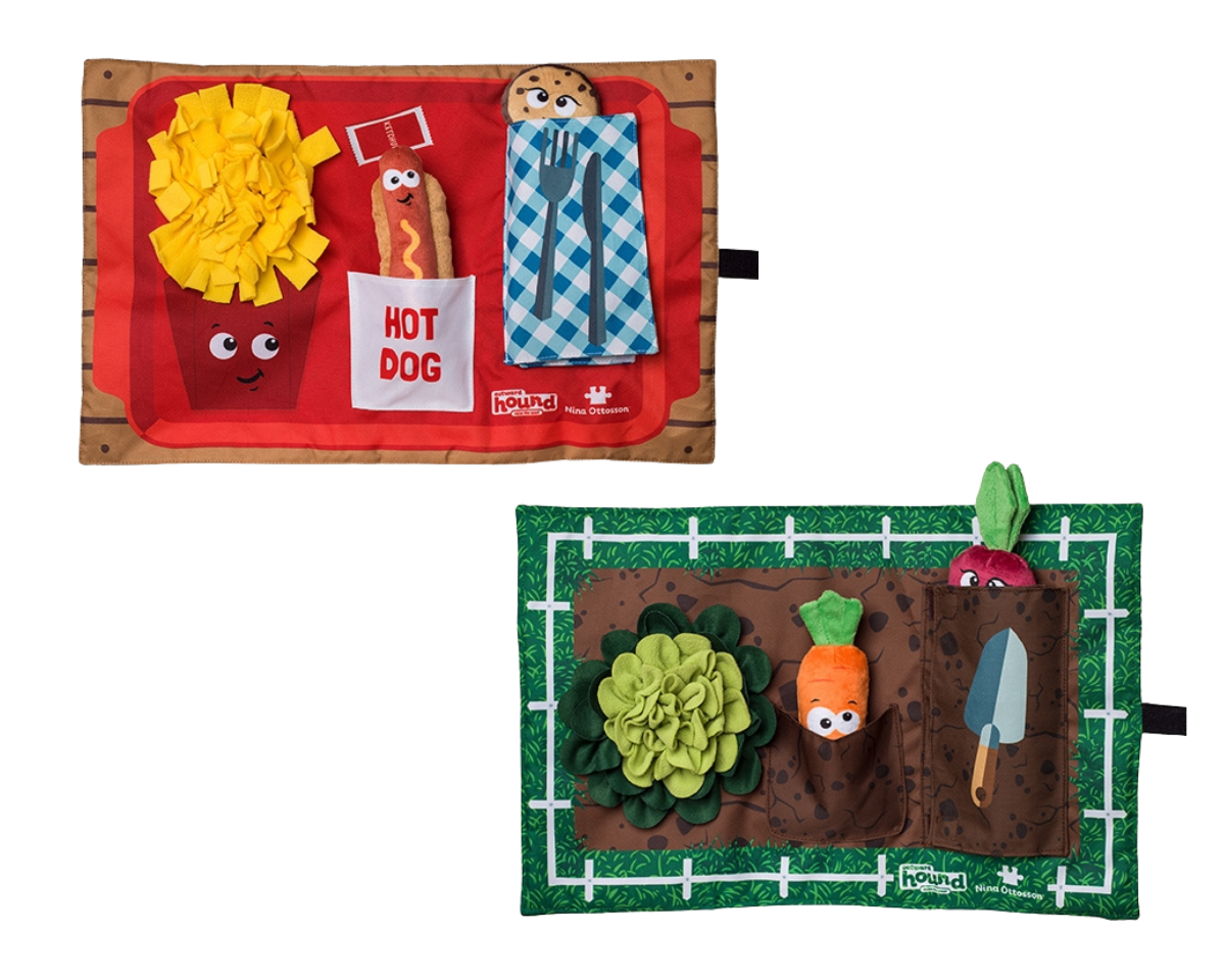 Two Nina Ottosson Enrichment Activity Mats for dogs. One has a red background with cartoonish dog and bone designs, and the other has a green background with a garden-themed design including vegetables and a watering can.