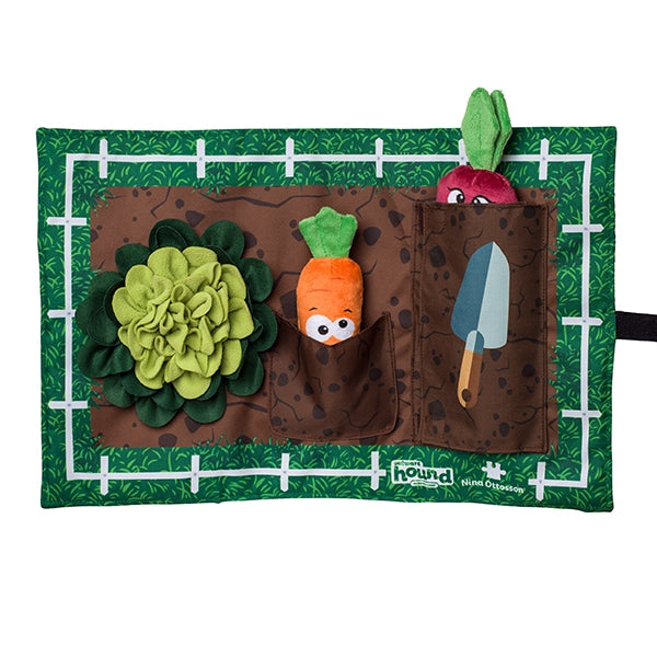Toy garden with plush flowers, carrot, and radish on a green background