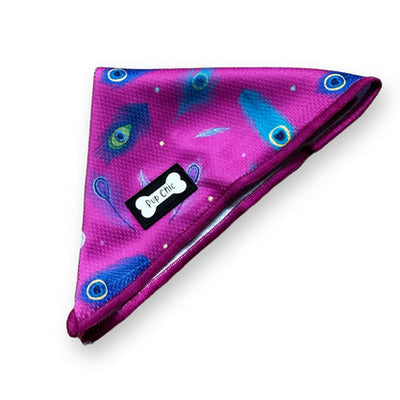Purple dog bandana with peacock feather pattern on a white background