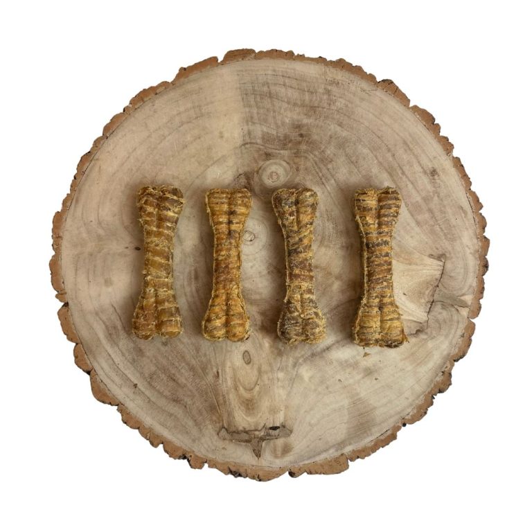 Four dog treats shaped like bones on a wooden surface