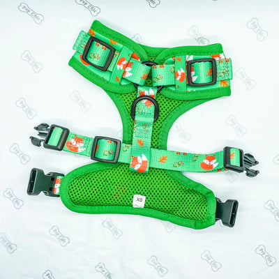 Green dog harness with orange fox pattern on a light grey background