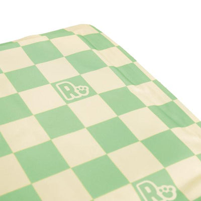 Checkered mat with green and beige squares and a logo in the center.