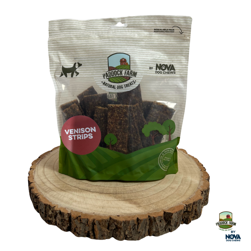 Pack of Paddock Farm Venison Strips natural dog treats shown on a wooden log slice, gluten-free and gently dried venison chews for dogs, stocked at Amy’s Pet Supplies.