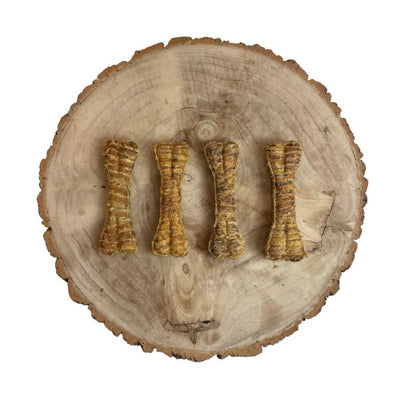 Four dog treats shaped like bones on a wooden surface