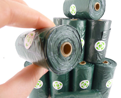 Close-up of Ecohound dog poo bag roll in hand, showing eco-friendly waste bags with tie handles and recyclable core
