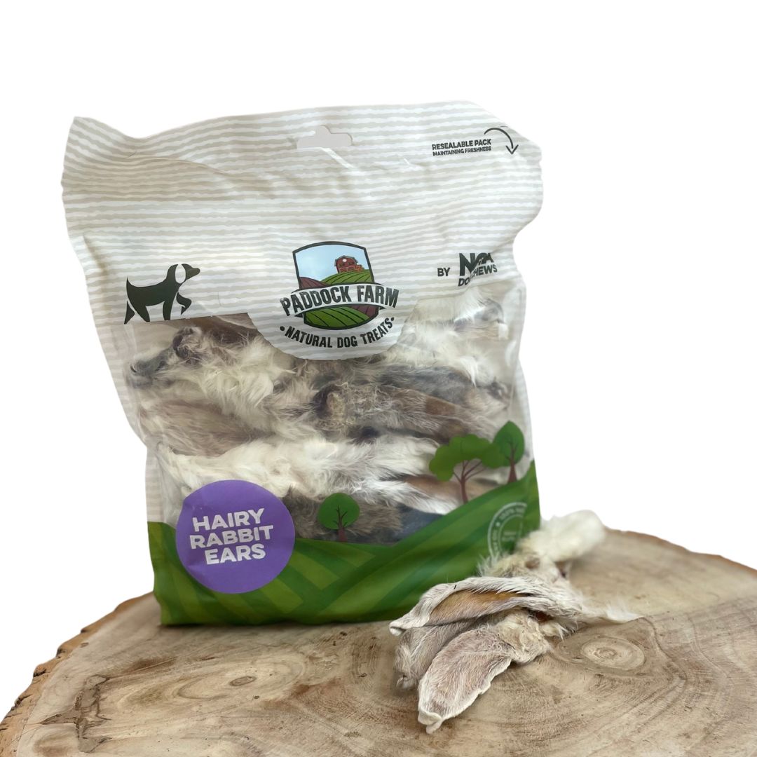 200g bag of Paddock Farm hairy rabbit ears natural dog treats on wooden surface, showing resealable eco-friendly packaging with dried chews displayed in front