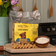 Betty Miller Everyday Liver Bones 500g dog biscuit bag with bone-shaped treats on a wooden board