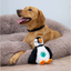 Dog relaxing in a bed beside the Örva Puffin Treat Belly enrichment toy