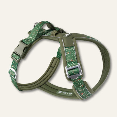Twiggy Tags Apex Nomad dog harness with green contour-pattern straps, olive padding, reflective trim, clip buckles and a padded back handle.