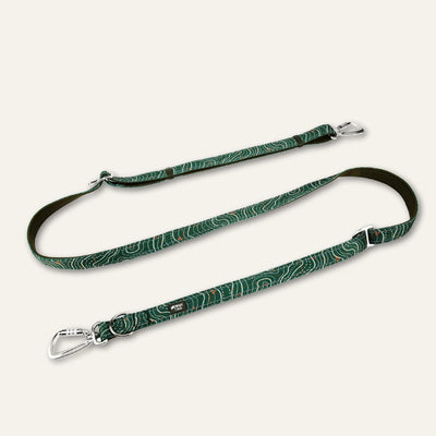 Twiggy Tags Nomad Multi-Way dog lead with green contour-pattern webbing, olive padding, two silver locking carabiners and adjustable metal rings.
