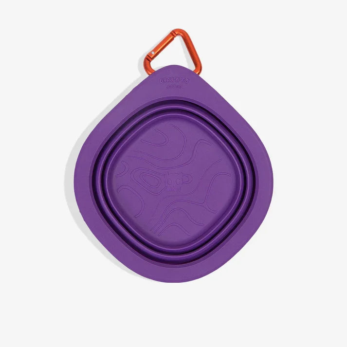 Zee.Dog GoBowl in Peak purple shown folded flat with an orange carabiner